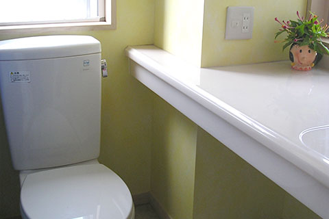 大きな洗面カウンターのあるトイレ。